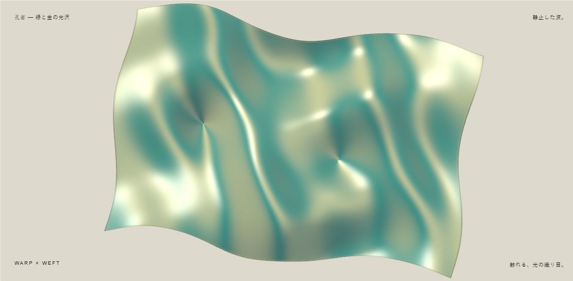織光の布展示。波立つ折れ目に、緑と金の光沢が見える画面。